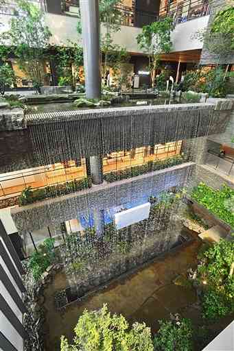アミュプラザくまもと内に造られた立体庭園「ぼうけんの杜」。３階の高さから滝が流れ落ちている＝２０日、熊本市西区（高見伸）