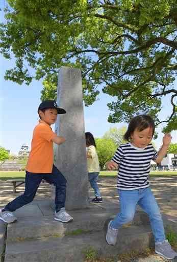 新緑に包まれる熊本城二の丸広場で遊ぶ子どもたち＝２１日午後２時半ごろ、熊本市中央区（小野宏明）