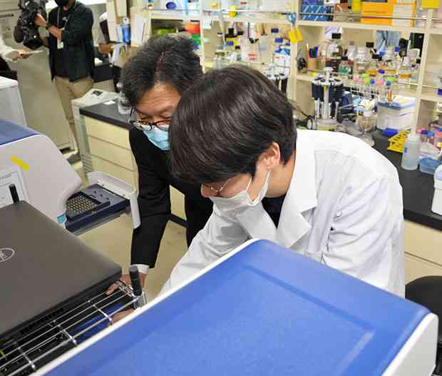 熊本大大学院生命科学研究部付属生体情報研究センターでＰＣＲ検査を行う大学院生ら＝２３日、熊本市中央区