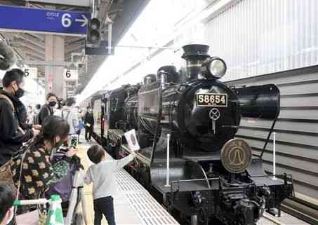 出発前の観光列車「ＳＬ人吉」を写真に収める乗客や見送り客たち＝１日、熊本市西区