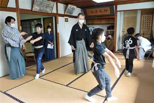 狂言師の指導を受けながら新作狂言の練習をする子どもたち＝熊本市中央区