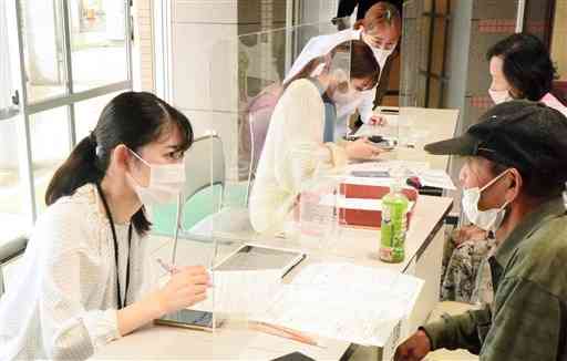新型コロナワクチン接種の予約を手伝うボランティアの学生たち＝大津町