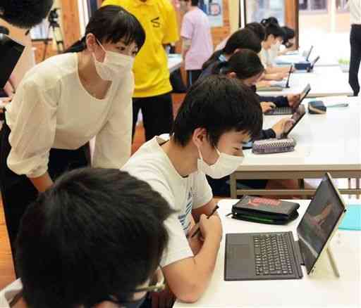 気象予報士の早田蛍さん（左）から気象データの見方について学ぶ坂本中の生徒たち＝八代市