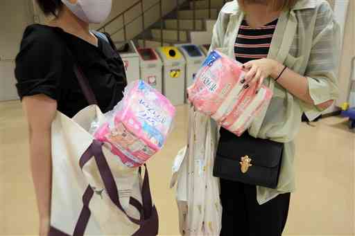 無償配布された生理ナプキンを手にする学生。「いつもできるだけ安いのを選んでいる。無償配布は助かります」と話す＝１１日、熊本市中央区