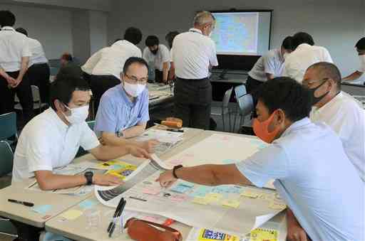 台風接近時の災害対応をまとめ、学校版のタイムラインを作る防災主任の教諭ら＝２２日、県庁