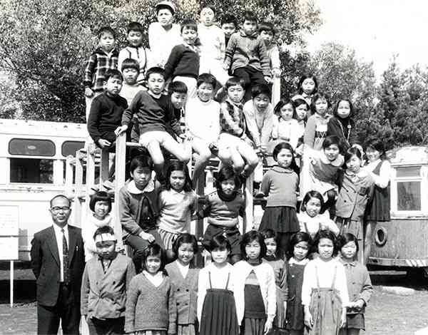小学３年時のクラス写真。左端が河野先生、その隣で鉢巻き風の包帯をしているのが私