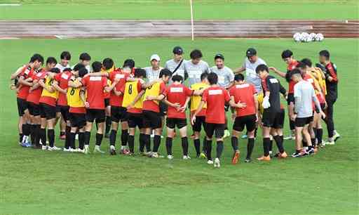 ９日の練習終了後に円陣を組むロアッソ熊本の選手とスタッフ＝県民総合運動公園補助競技場