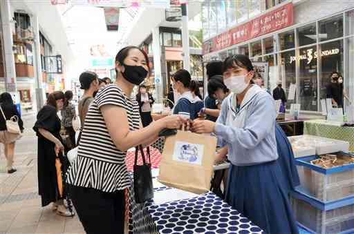 食品ロス削減イベントで菓子を販売する熊本学園大付属高の生徒（右）。下の写真はイベントで販売した菓子＝熊本市