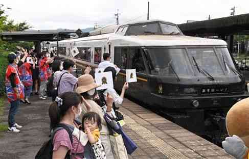ＪＲ阿蘇駅で、運行開始１０周年を迎えた豊肥線の観光列車「あそぼーい！」を見送る地元住民ら。コロナ禍で他の観光列車が苦戦する中、高い乗車率を保っているという＝６月、阿蘇市