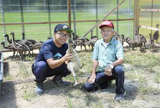 エミューの飼育場を開場した農事組合法人「鶴喰なの花村」の松村梅雄代表理事（右）と飼育担当の宮川智光さん＝八代市