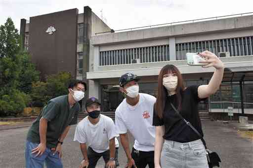 解体される校舎をバックに記念写真に納まる多良木高最後の卒業生たち＝多良木町