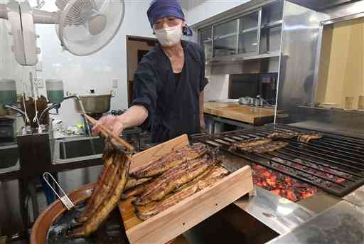 秘伝のたれ（左下）を作り直し、試し焼きをする上村うなぎ屋の上村元気さん＝９日、人吉市（小野宏明）