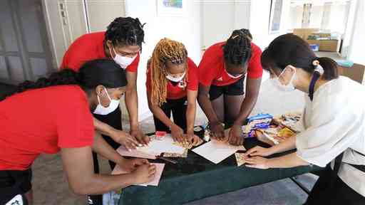 滞在先のホテルで折り紙を教わるアンゴラの女子ハンドボール代表選手ら＝玉名市（同市提供）