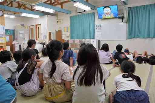 植木小の学童保育すいかクラブで、アニメを楽しむ子どもたち。「密」の解消が難しいという＝１２日、熊本市北区