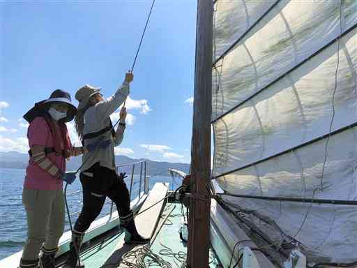 うたせ船の帆を張るケビンさん（右）と田川沙由里さん夫妻＝芦北町