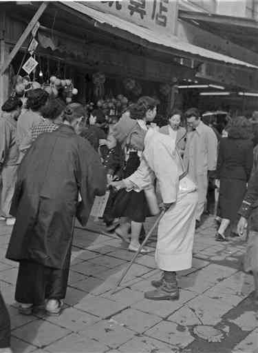 熊本市の下通商店街で街頭募金する傷痍軍人＝１９５３年１１月