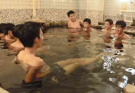 １０月１日にプレオープンする人吉旅館の温泉を楽しむ球磨工高の生徒たち＝人吉市