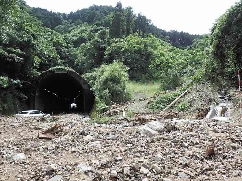 昨年７月の豪雨で被害を受けた国道３号の海浦トンネル付近。大量の土砂に埋もれた車が乗り捨ててあった＝２０２０年７月４日、芦北町（県地質調査業協会提供）