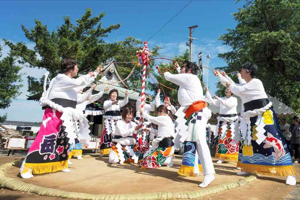 土俵を固める儀式で、土つき棒で地面をつく千丁町女相撲保存会のメンバーら＝八代市（八代市日本遺産活用協議会提供）