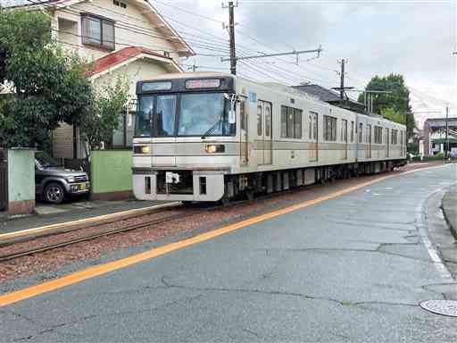 民家の玄関や車庫の前を通過する電車。全国的にも珍しい光景だ