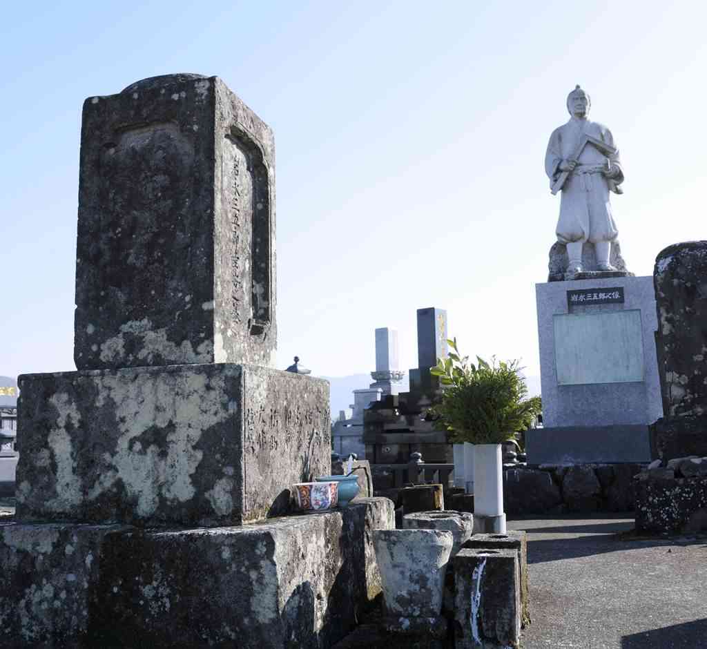 干拓事業や石橋造りで活躍した岩永三五郎の墓。そばには石像が立っている＝八代市