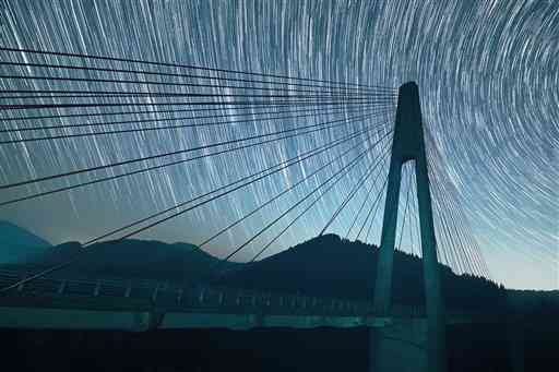 鮎の瀬大橋と西の空に沈む星々＝２５秒露出の７４枚を比較明合成