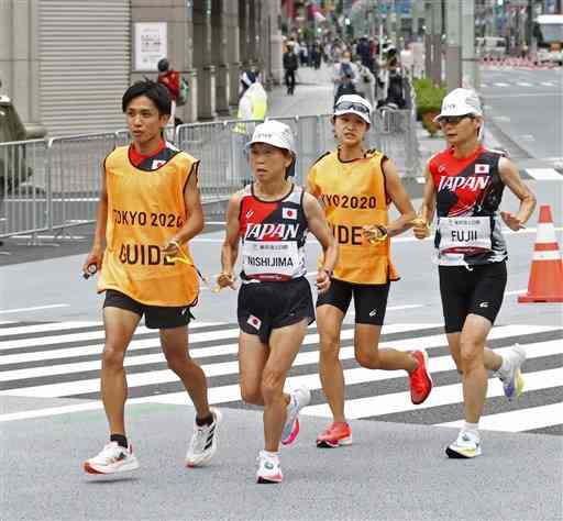 女子マラソン（視覚障害Ｔ１２）の１０キロ付近を力走する西島美保子（左から２人目）と伴走者の宮崎勇将さん（左）＝東京都内