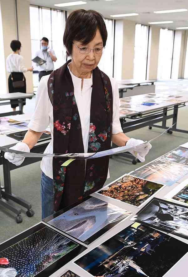 熊日写真展の１次審査をする日本写真家協会会員の大石芳野さん＝１５日、熊日本社（高見伸）