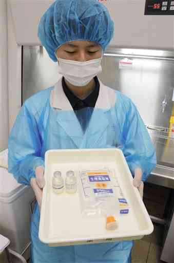 抗体カクテル療法に使われる薬剤を手にする熊本市の桜十字病院のスタッフ＝同市南区
