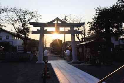 日吉神社に建つ鳥居の２本の柱の間から昇る太陽＝熊本市南区