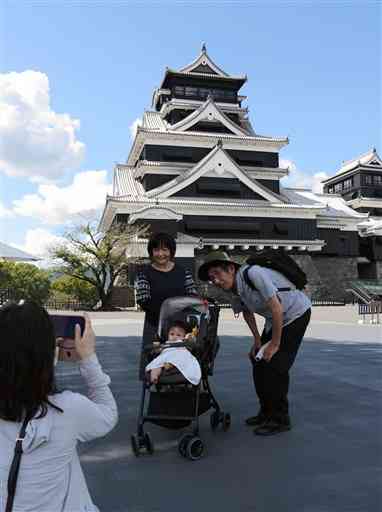 特別公開が再開された熊本城天守閣前で記念撮影する親子連れ＝熊本市中央区