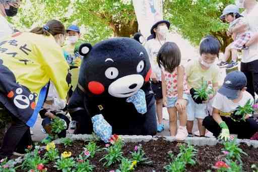 子どもたちと一緒に花を植えるくまモン＝熊本市中央区