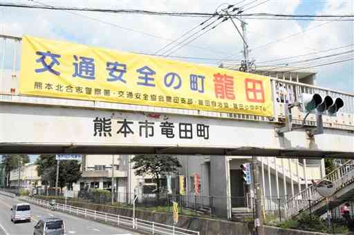 龍田小前の歩道橋にかかる横断幕は「龍田」だが、下の表記は「竜田町」となっている＝熊本市北区