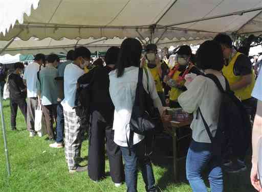 無料の食料配布会に列をつくる学生たち＝３日、熊本市東区