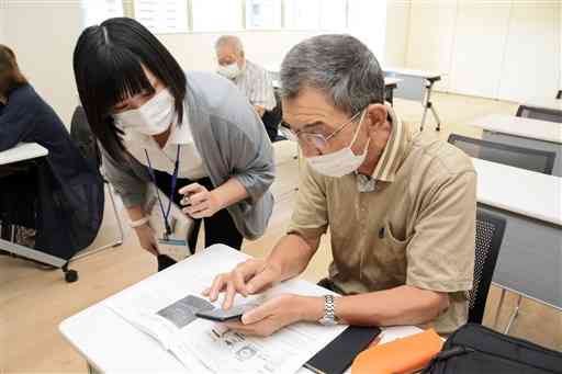ＬＩＮＥ安全活用講座でスマートフォンの使い方を習う高齢者ら＝１０月、熊本市中央区