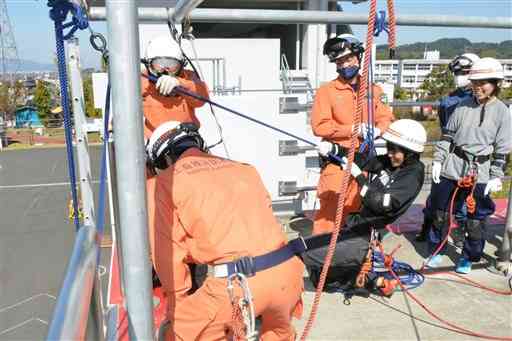 命綱を装着し、７メートル下にいる負傷者を引き上げる救助訓練を体験する学生（右から３人目）ら＝御船町