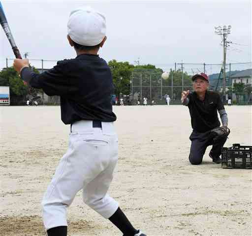 とみあい総合型クラブで小学生の野球を指導する三角陽司マネジャー（右）＝熊本市南区