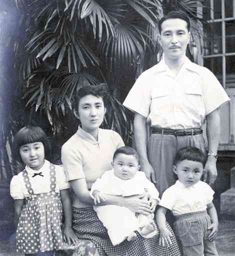 自宅前で父母と弟たちと一緒に写真に収まる幼い頃の筆者（左端）