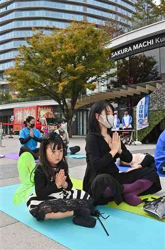 ハロウィーンの仮装をしてヨガを楽しむ親子＝３０日、熊本市中央区