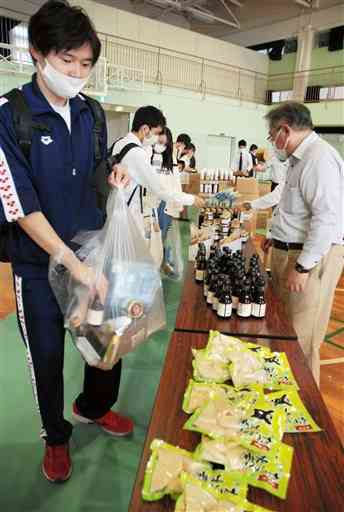 無料配布された食品を持ち帰る熊本大の学生たち＝２日、熊本市中央区