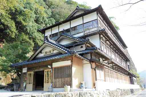 １年４カ月ぶりに営業を再開した木造３階建ての鶴之湯旅館＝八代市