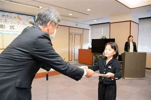 九州電力の川畑健二熊本支店長から賞状を受け取る九電賞の田代結生さん（右）＝３日、熊本市中央区