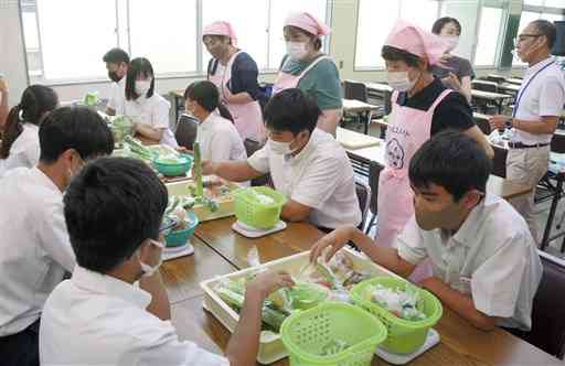 高校生に食生活の大切さを伝える荒尾市食生活改善推進員協議会のメンバーら（ピンク色のエプロンの３人）＝同市