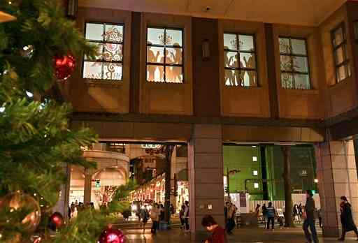 クリスマスの家族のだんらん風景などをテーマにした映像が投影されたびぷれす広場の窓＝１２日夜、熊本市中央区（後藤仁孝）