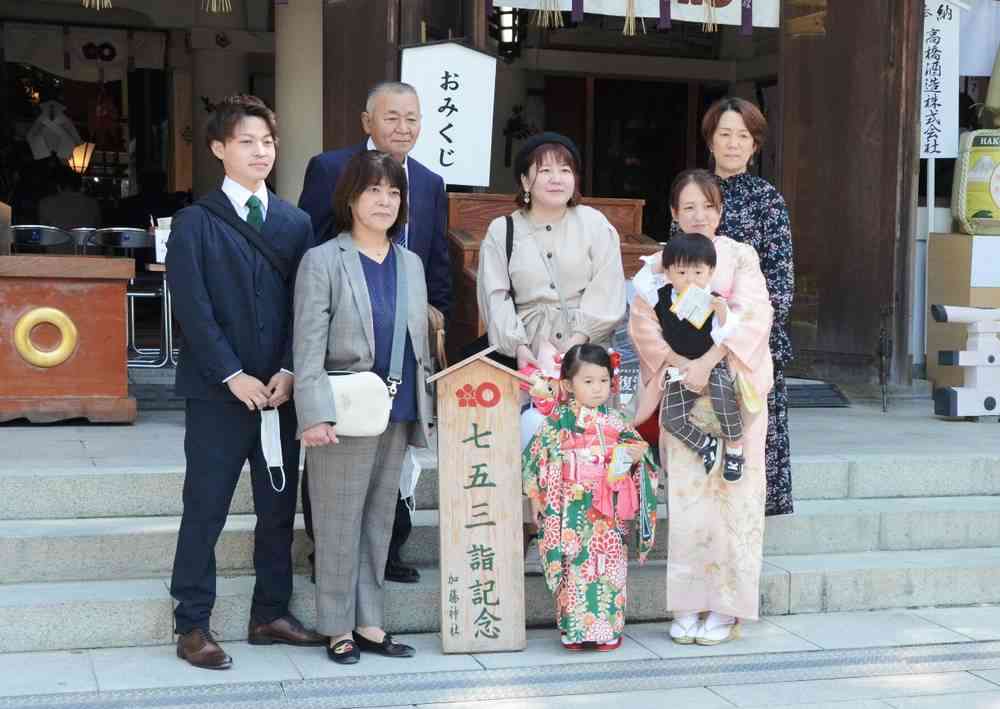 家族で写真に収まる参拝客ら＝１５日、熊本市中央区