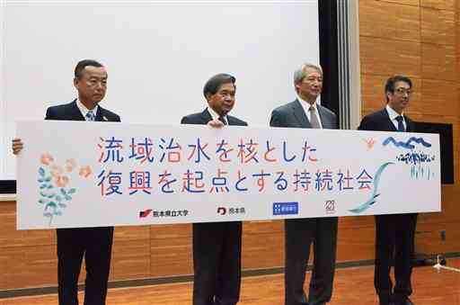 共同研究のテーマの横断幕を掲げる蒲島郁夫知事（左から２人目）ら＝１７日、熊本市東区