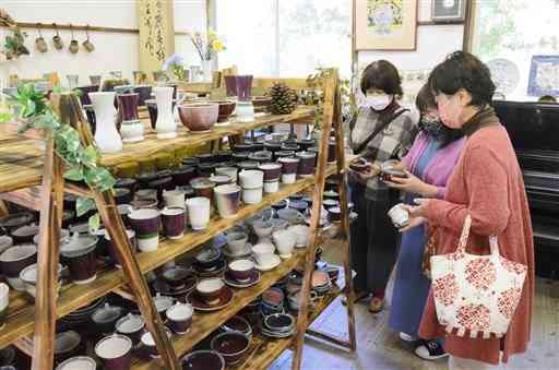 「秋の窯出し」が開かれている天竺窯で、熱心に品定めをする来場者＝苓北町