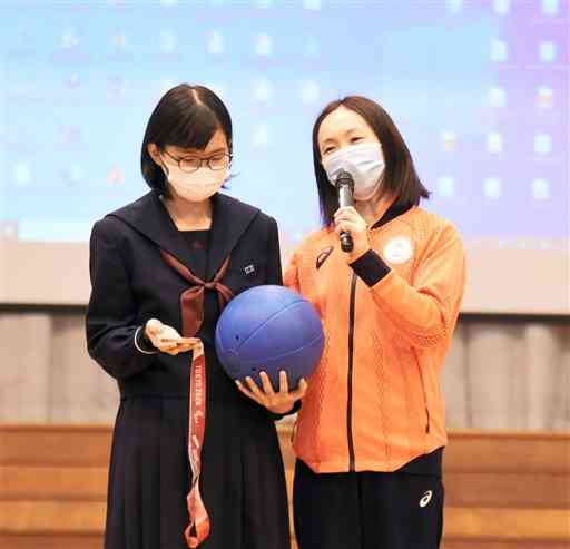 ゴールボール女子日本代表の浦田理恵さん（右）の講演では、銅メダルと競技用ボールの重さに関するクイズを生徒に出す場面もあった＝山鹿市