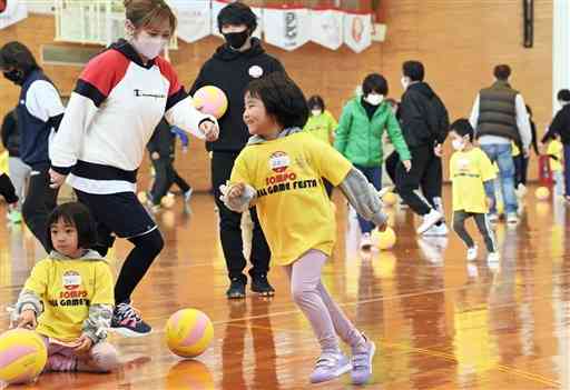 サッカー元日本代表の佐藤寿人さん（中央奥）が見守る中、ボールで遊ぶ子どもたち＝阿蘇市