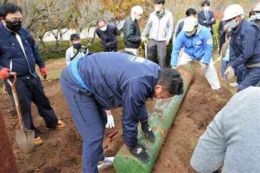 ２０年前に埋められたタイムカプセルを掘り起こす和水町職員ら＝同町